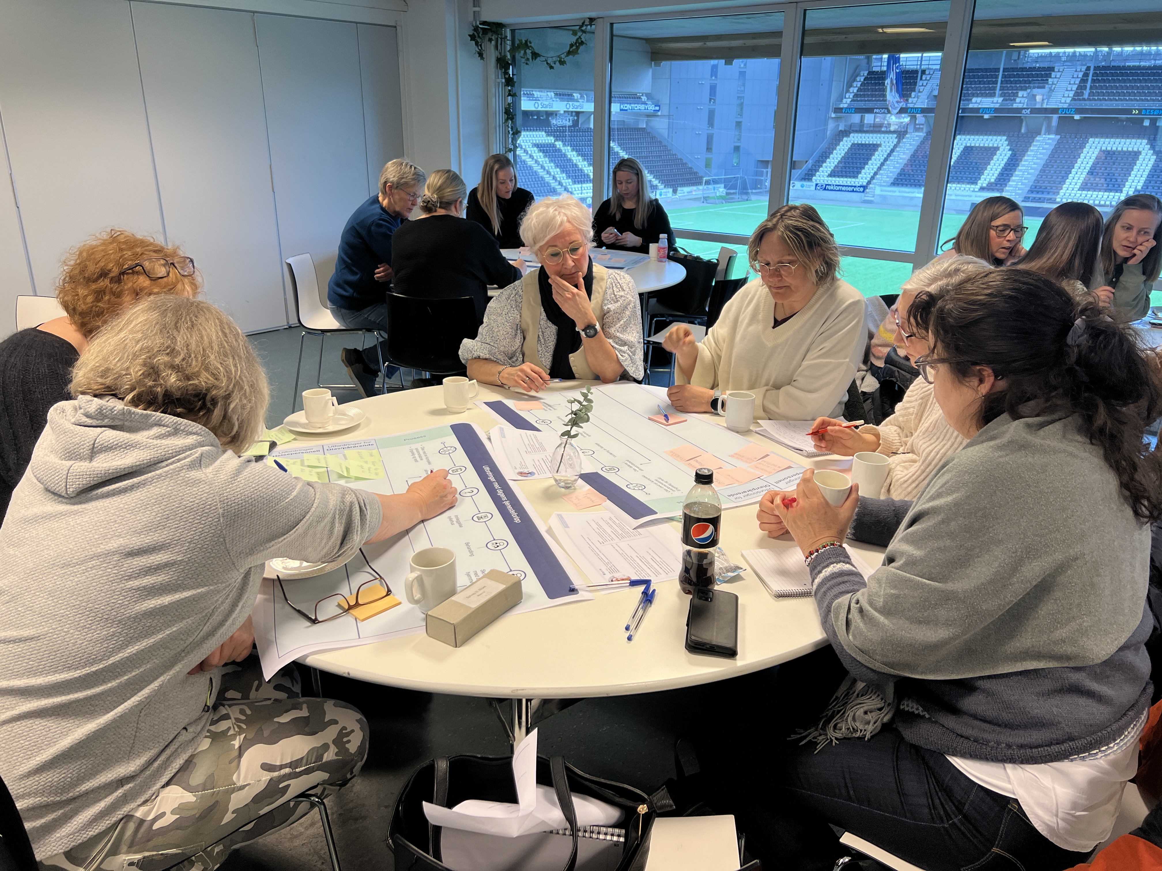 Mennesker som samarbeider rundt et bord, foto.